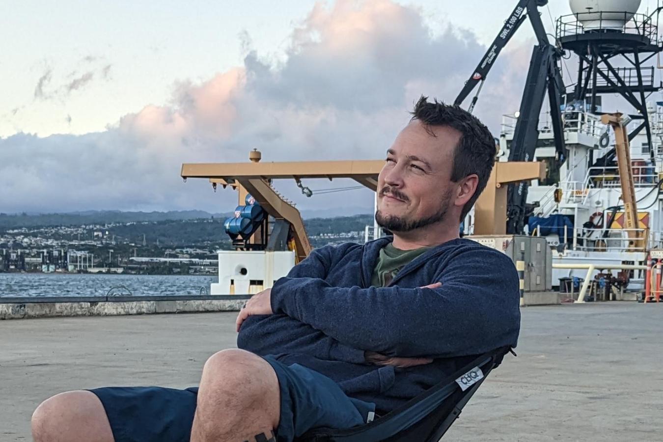 Mariner Jason Dlugos enjoying the sunset on the dock in front of NOAA Ship Oscar Elton Sette.