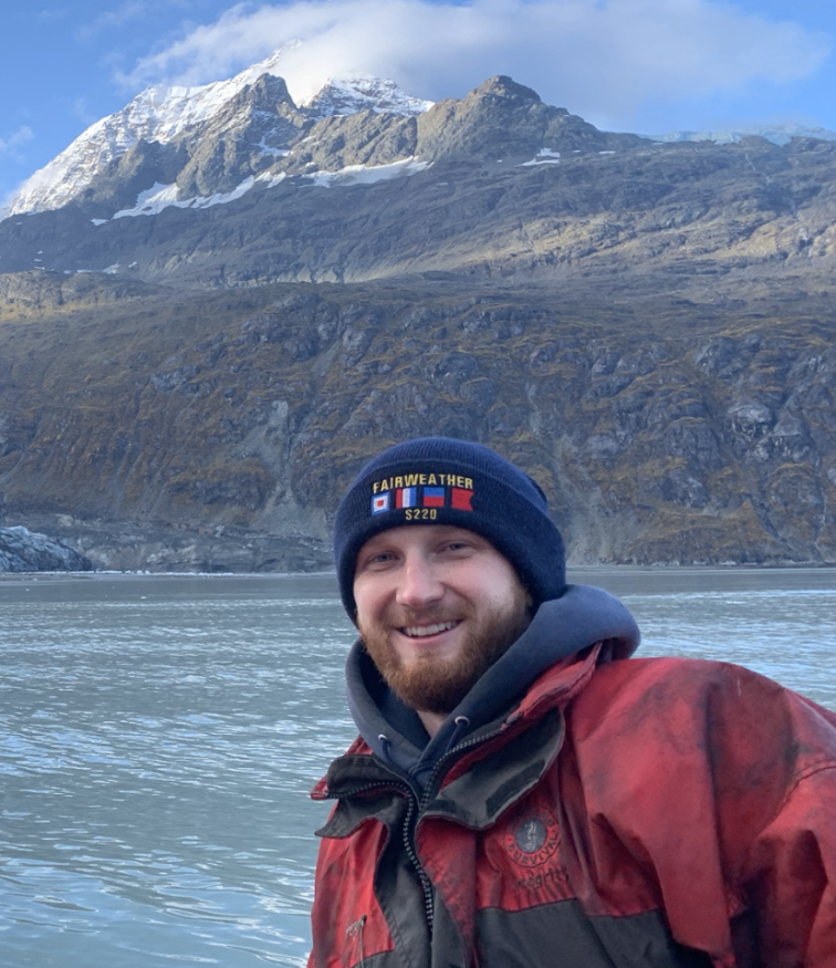 Sean Battles in a small boat in front of Mount Fairweather