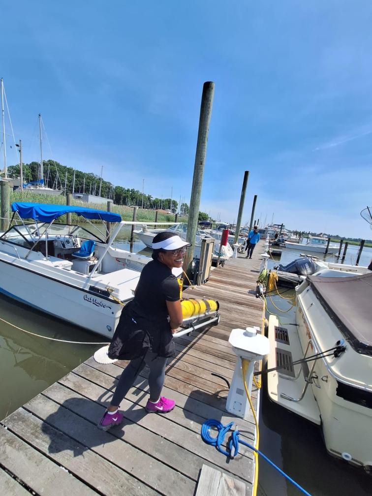 Knauss Fellow, Chesna Cox, wheels a glider on a cart down a dock.